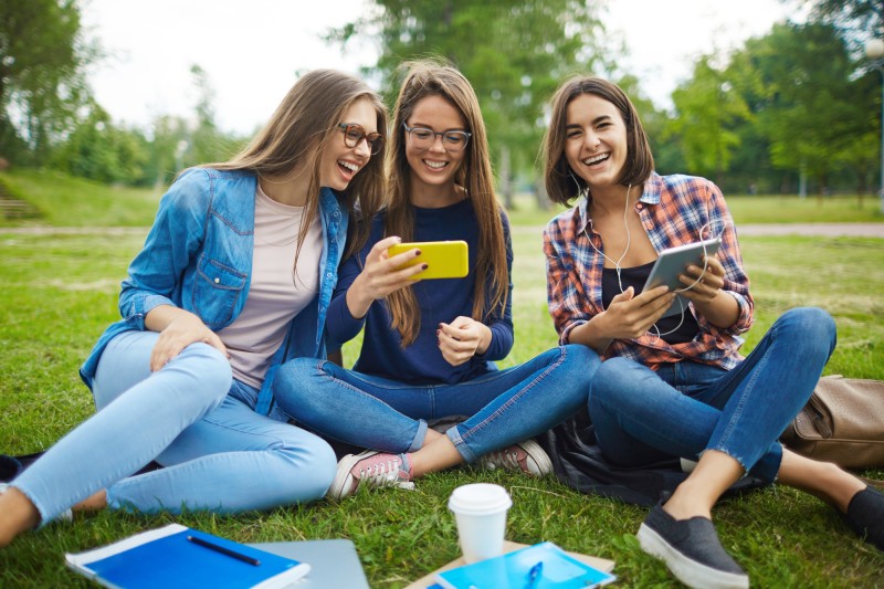 girls with phones in park